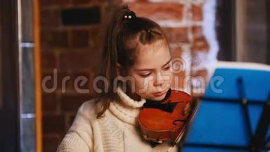 穿着白色毛衣拉小提琴的漂亮小女孩